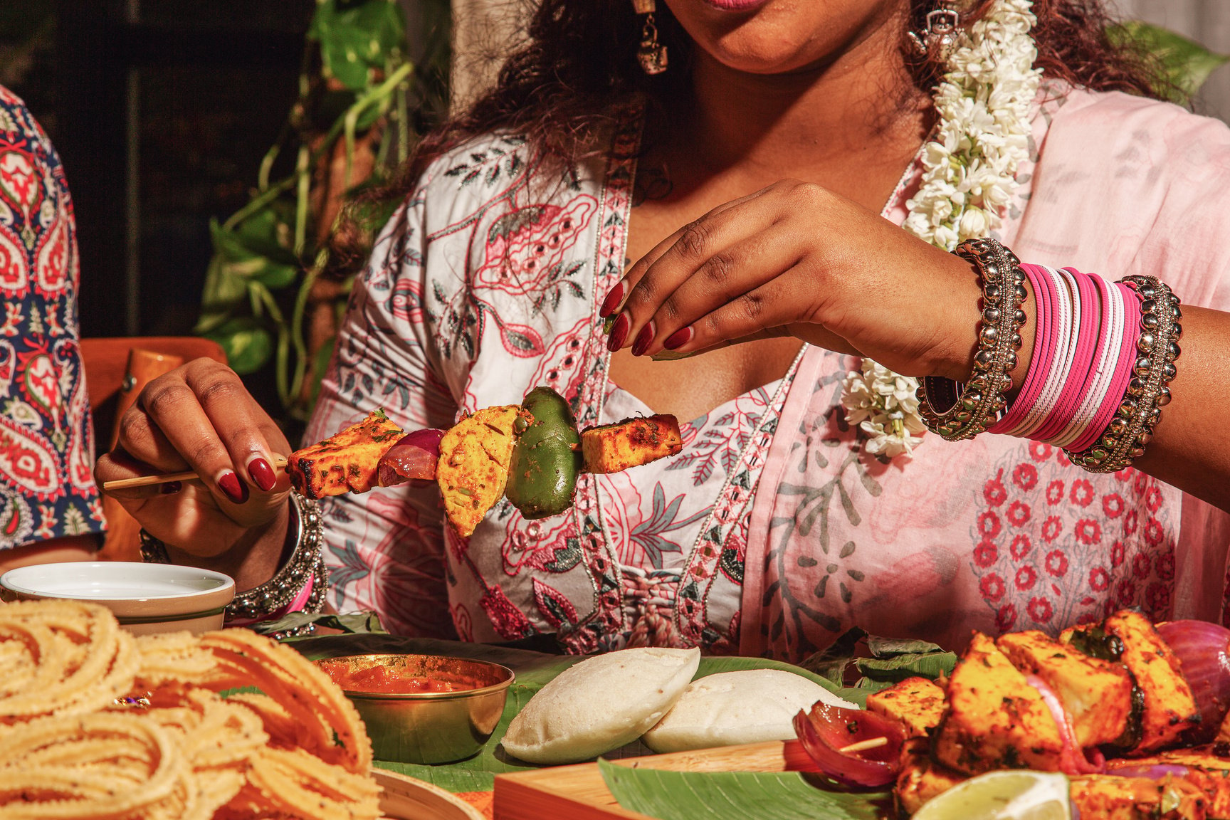 Person Taking a Stick of Paneer Tikka 